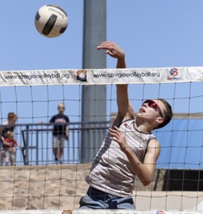 Parker Conley hitting a cut shot during a beach volleyball tournament at Victory Lanes.