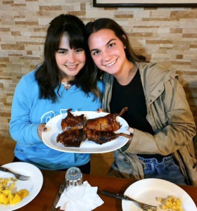 Jacqueline, left, and Natalie prepare to dig into a plate of cooked Guinea pig.